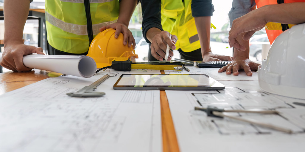 Équipe d'ingénieurs BTP sur plans de construction, création d'entreprise bâtiment
